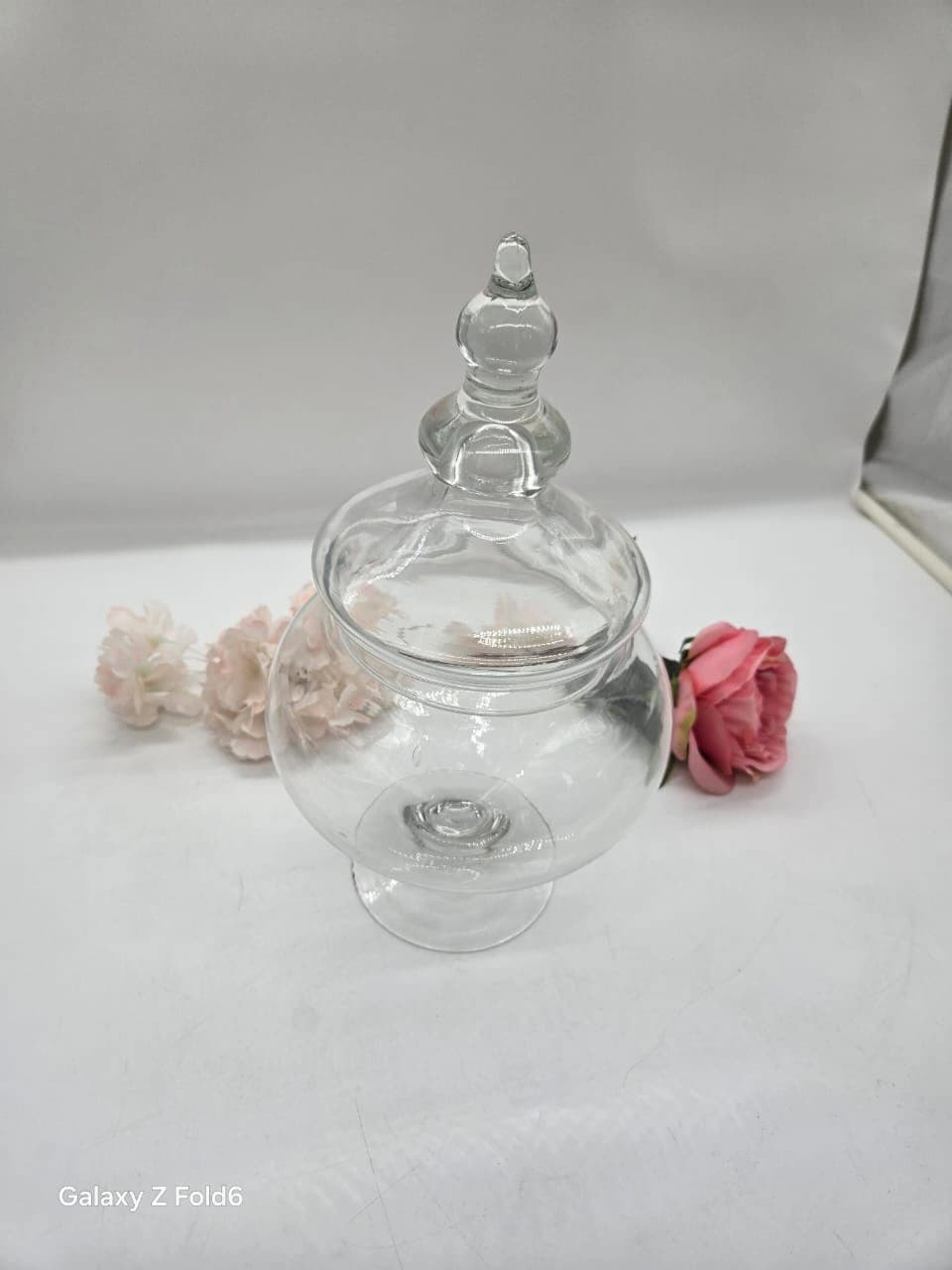 Bonbonnière d’apothicaire en verre transparent, bol arrondi sur pied et couvercle orné d’un fleuron décoratif