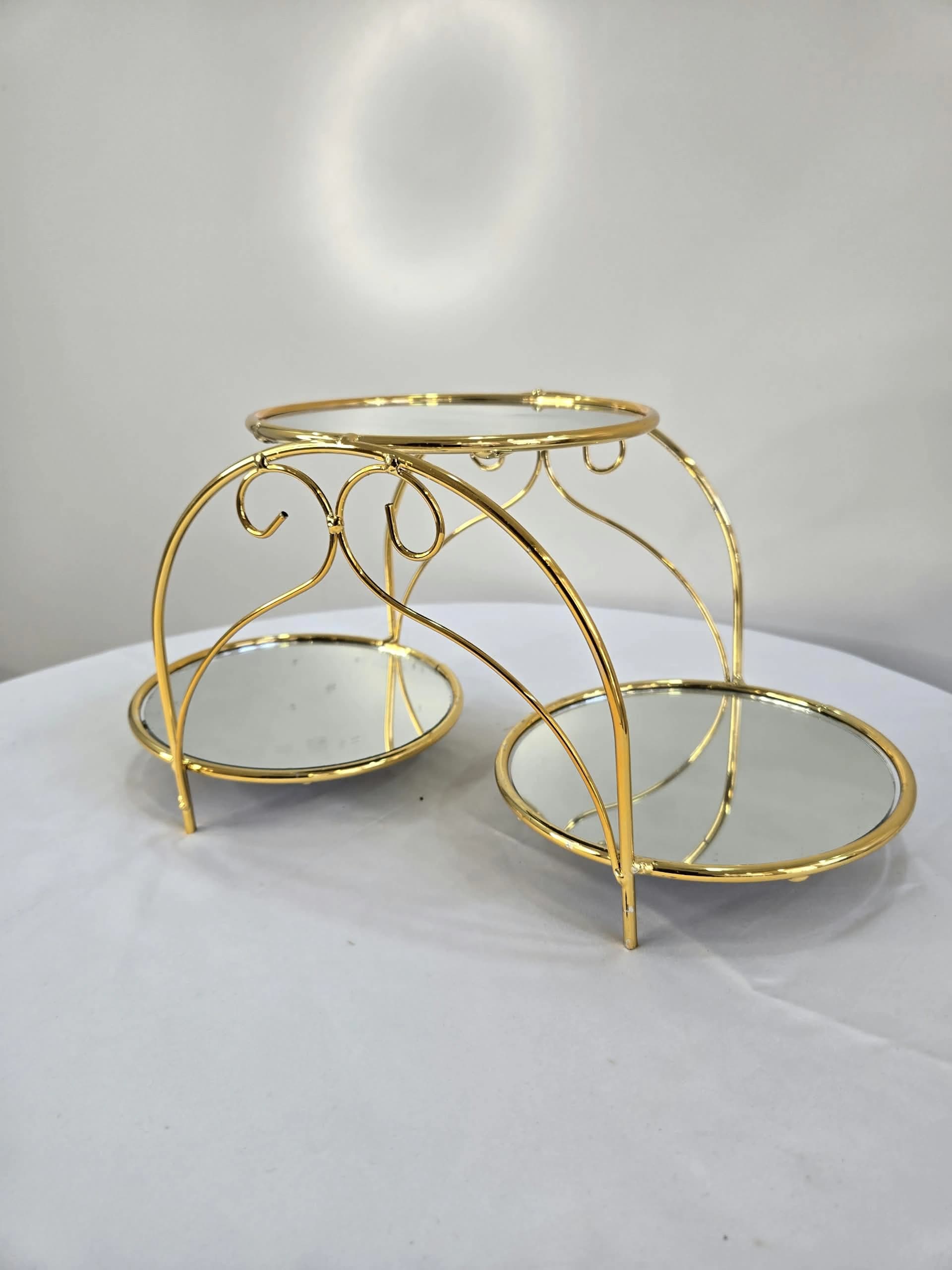 Présentoir à plusieurs niveaux en métal doré, orné de plateaux circulaires en miroir et de volutes décoratives