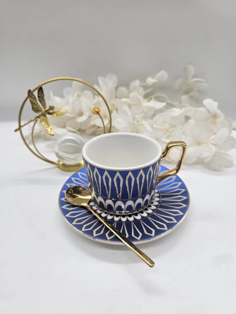 Tasse et soucoupe en porcelaine bleue et blanche à motif géométrique, anse bordée d’or et cuillère dorée
