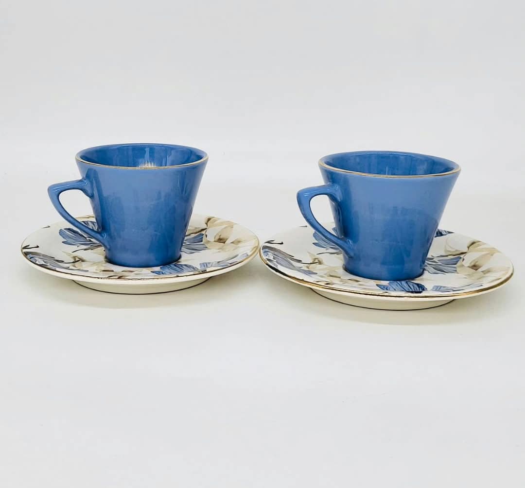 Tasses bleues à liserés dorées accordées à des soucoupes à motifs floraux