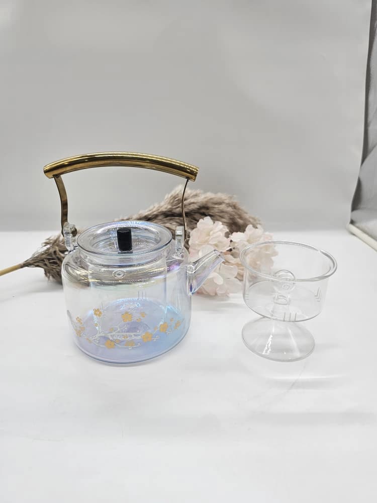 Théière en verre irisé ornée de délicats motifs floraux dorés et d’une anse arquée dorée polie