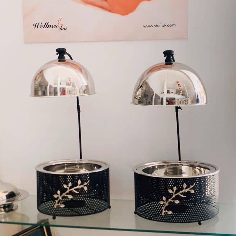 Deux chafing dishes de buffet avec couvercles relevés, posés sur leur support