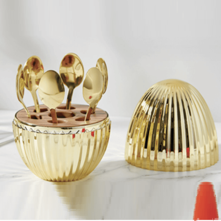 Set de pièces de service en inox brillant, groupées sur fond neutre